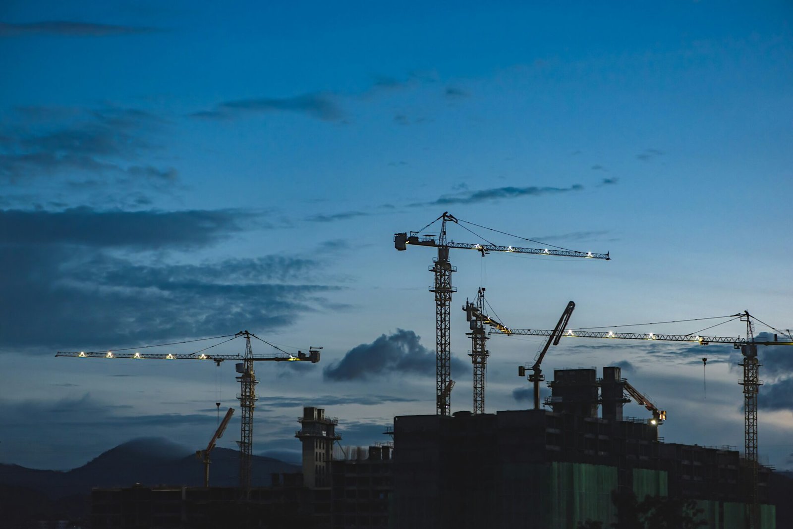 Construction site with tower cranes at dusk